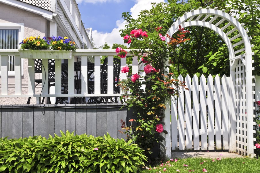 Arched house entry arbor with gate and matching white deck railing