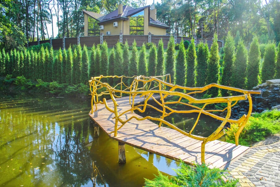 This amazing pond bridge design features railing made from tree branches